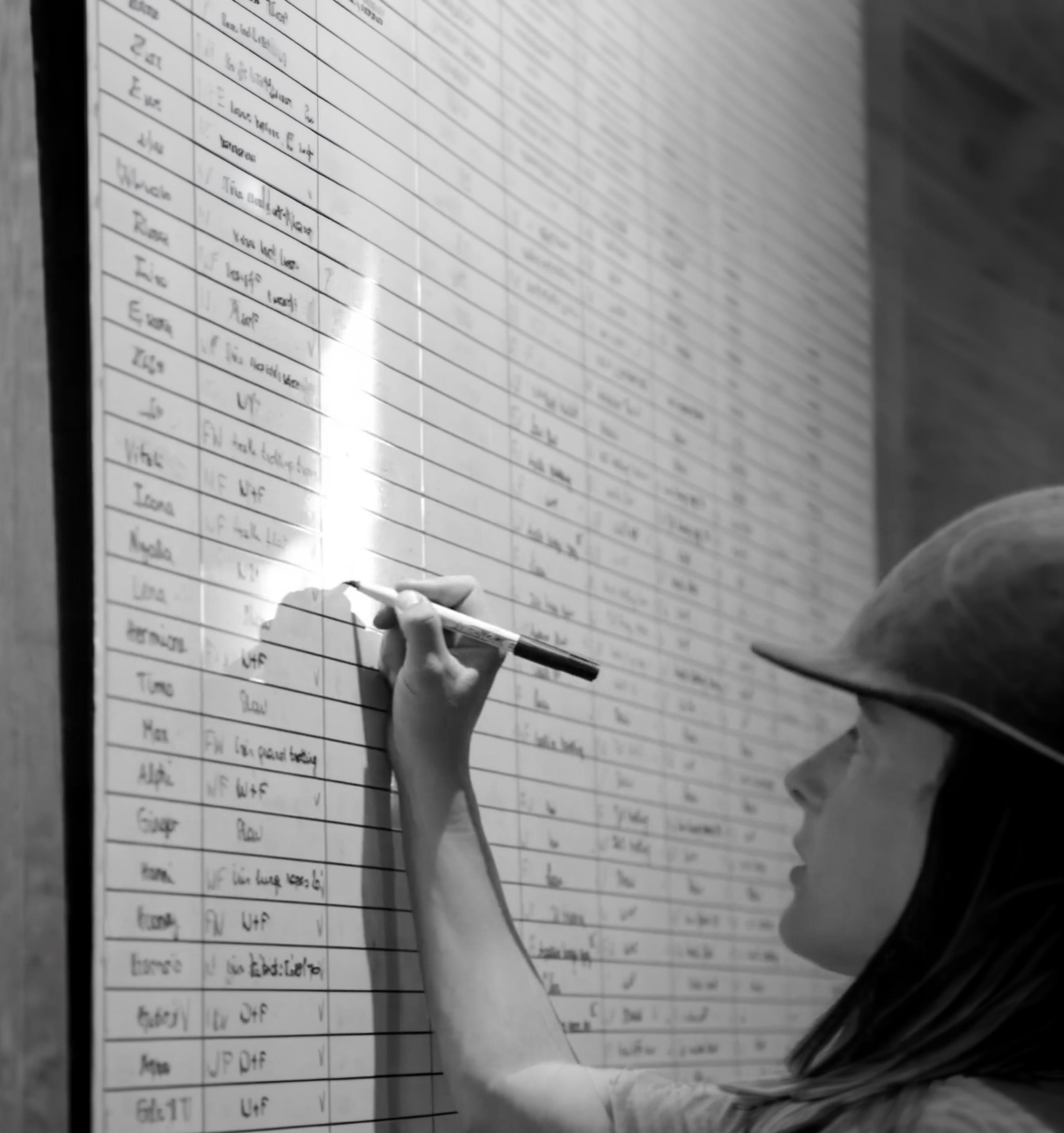 Une cavalière note des informations sur le tableau blanc de l'écurie